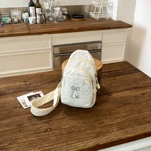 Casual λευκή τσάντα στήθους από καμβά με χαριτωμένο κέντημα φιόγκου για καθημερινή χρήση.