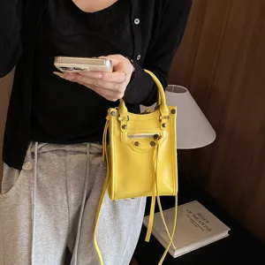 Chic yellow mini leather crossbody bag with zipper pockets and stylish metal stud details.