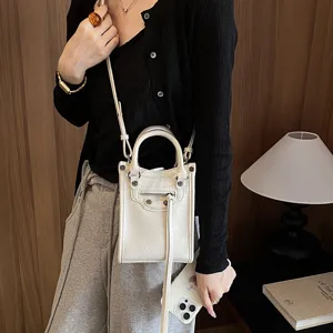 Mini white crossbody phone bag, stylish leather shoulder bag with zipper and tassels.