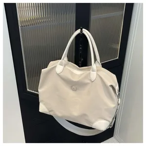 Bolso de viaje grande en color marfil con correa para el hombro y detalles en piel blanca.