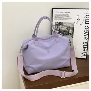 Gran bolsa de viaje en lila claro con correa ajustable para el hombro y asas dobles.