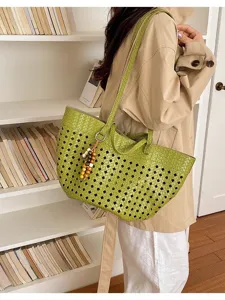 Detailed view of casual green woven tote bag with bead charm, stylish lifestyle scene.