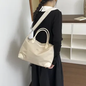 Bolsa de viaje beige de gran capacidad con asas y correa para el hombro ajustable y cómoda.