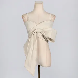 Top beige chic avec devant portefeuille et grand nœud remarquable pour les vacances d'été.