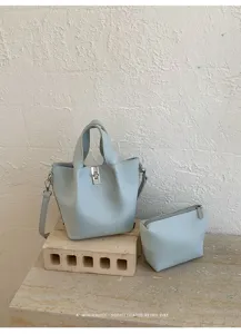 Dettagli della chic borsa a secchiello azzurro con pochette abbinata, stile minimalista.