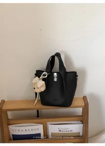 Vista dettagliata di un'elegante borsa a secchiello in pelle nera con chiusura.