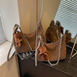 Braune gewebte Umhängetasche für Damen mit Metallkettengurt und süßem Bärenanhänger Detail.