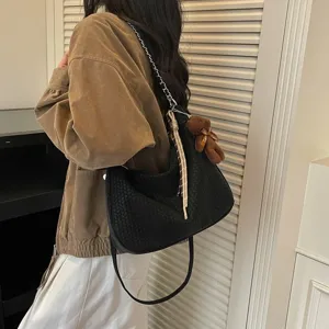 Gewebte Umhängetasche für Damen, minimalistische Hobo-Dumpling-Tasche mit Bärenanhänger.