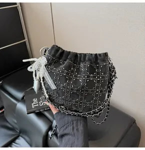 Black studded bucket bag with chain strap, stylish drawstring shoulder bag for daily women use.