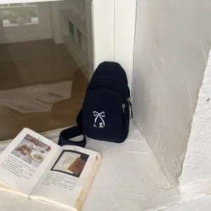 Μαύρη ναιλον τσάντα στήθους λεπτομερής άποψη με χαριτωμένο κέντημα φιόγκου για μετακινήσεις.