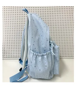 Gros plan détaillé du sac à dos décontracté bleu clair avec imprimé étoiles et poche latérale.