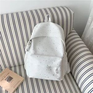 Vue détaillée d'un sac à dos d'école blanc décontracté avec motif d'étoiles argentées.