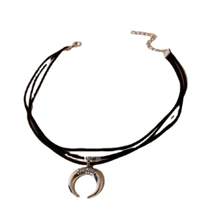 Collier ras du cou multicouche en cordon noir avec pendentif croissant de lune argenté.