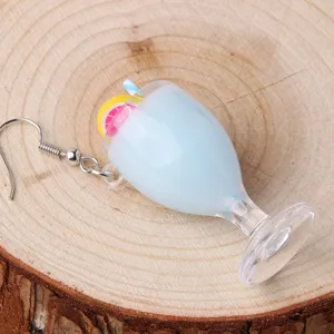 Detail shot of cute blue juice cup resin dangle earrings with lemon and straw design.
