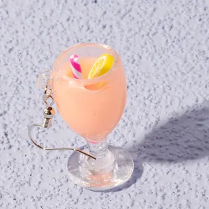 Close-up of a cute miniature juice glass earring with a straw and lemon slice detail.
