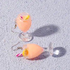 Close-up detail of cute mini fruit juice cocktail cup drop earrings, beach style fashion jewelry.