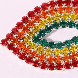 Close-up of vibrant rhinestone lip pendant, showing colorful crystals and metal setting detail.