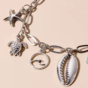 Nahaufnahme Detail der silbernen Strand Anhänger Fußkette mit Muschel und Schildkröte.