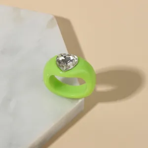 Green acrylic heart ring detail, clear close-up shot showing resin chunky band and crystal.