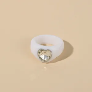 White acrylic heart ring detail shot, stylish and minimalist diamond-set design for women.