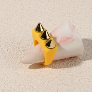 Yellow acrylic ring featuring stylish gold spike studs, punk rock style fashion finger jewelry.