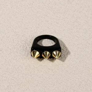 Detail view of a stylish black acrylic ring featuring three gold punk spike studs for women.