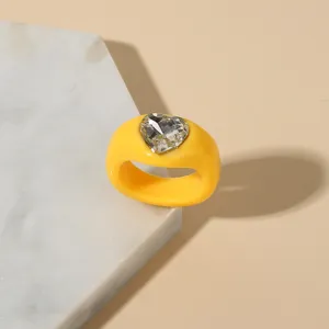 Detailed closeup of the stylish yellow acrylic chunky ring featuring a sparkly heart crystal inlay.