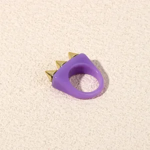 Chic purple acrylic ring featuring gold tone spikes, trendy punk style statement jewelry.