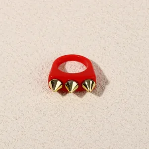 Red acrylic ring with three gold spikes, punk style statement finger jewelry for women.