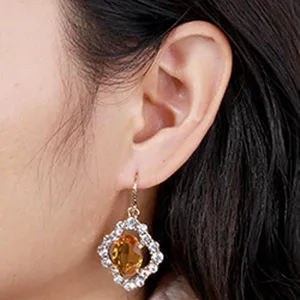Women fashion crystal dangle earrings with yellow main stone and clear rhinestones.