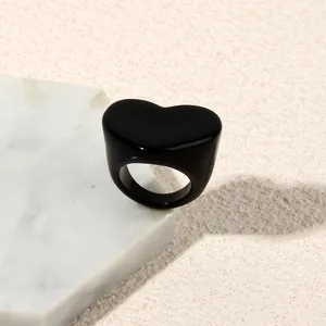 Minimalist black heart acrylic ring, elegant detail close-up view for women fashion.