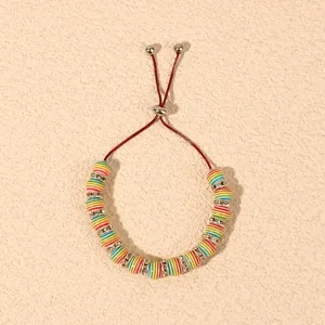Close-up detail of adjustable beaded bracelet with colorful striped beads and rhinestones.