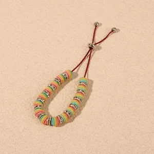 Close-up detail of colorful polymer clay heishi beaded adjustable bracelet with rhinestones.