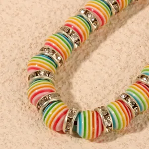 Colorful striped beaded bracelet detail showing vibrant round beads with rhinestone spacer rings.