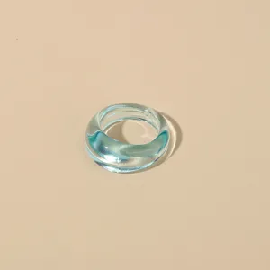 Close-up of a stylish transparent light blue acrylic ring, minimalist resin design.