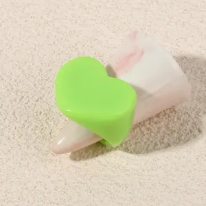 Green heart acrylic ring detail shot, minimalist geometric resin fashion finger jewelry.