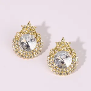 Detailed close-up of vintage gold-tone rhinestone crystal earrings, sparkling elegant design.
