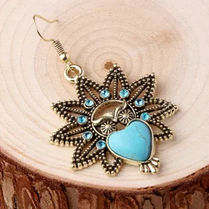 Close-up detail shot of vintage retro blue turquoise heart owl pendant dangle earring design.