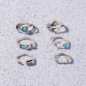Close-up view of bohemian silver ring set featuring turquoise stones and geometric designs.