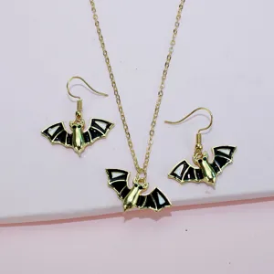 Detailed view of the Halloween bat pendant necklace and matching earrings set in gold and black.