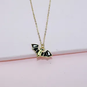 Gold tone bat pendant necklace with black enamel, gothic Halloween jewelry accessory for women.
