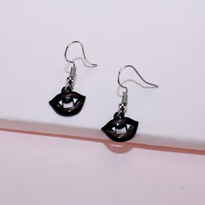 Close-up of quirky vampire lips dangle earrings, perfect for Halloween novelty jewelry.