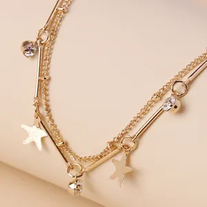 Primo piano dettagliato del bracciale a catena dorata multistrato con charm di stelle marine.