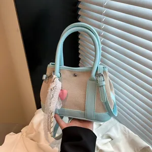 Detalle del bolso de hombro de lona, detalles en azul claro, lindo colgante de encaje.