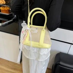 Elegante bolso de lona y cuero amarillo para mujer con lazo de encaje y correa de hombro.
