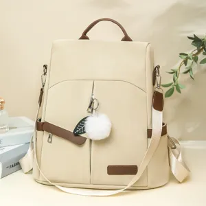 Sac à dos femme minimaliste chic beige avec détails marrons et un charmant pompon de feuille.