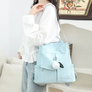 Élégant sac à dos bleu clair pour femme, sac bandoulière polyvalent avec charm pelucheux.