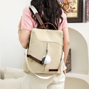 Vue détaillée du sac à dos beige et marron porté par le modèle, montrant son style.