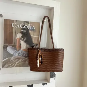 Καφέ πλεκτή δερμάτινη τσάντα ώμου tote shopper με κρεμαστό φούντα από χάντρες λεπτομέρεια.