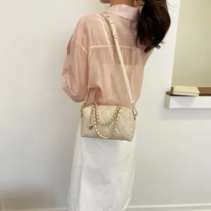 Stijlvolle gewatteerde schoudertas in Koreaanse stijl met elegante gouden ketting op model.